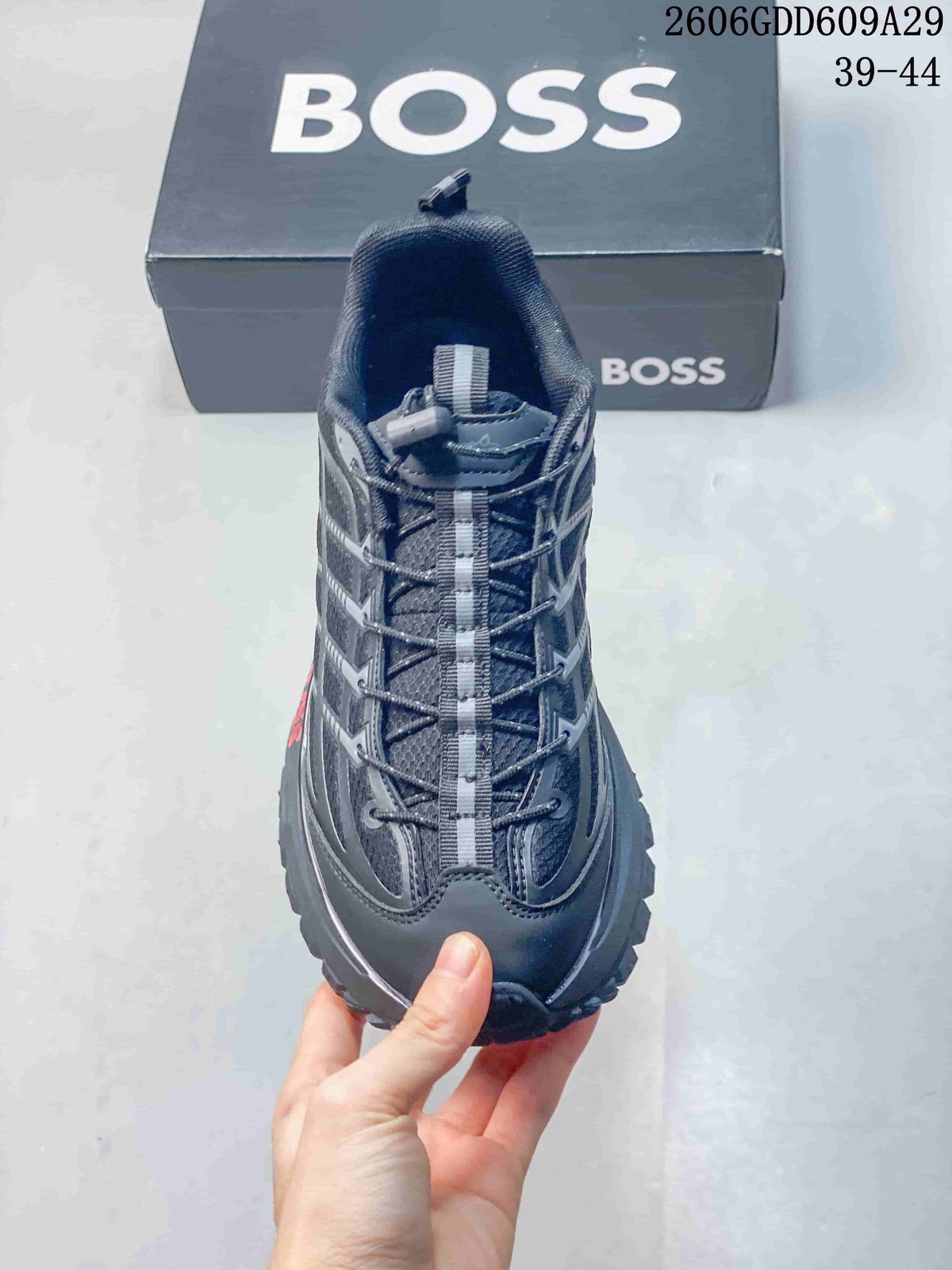 Front view of the gray sneaker showing its laces and central webbing detail.