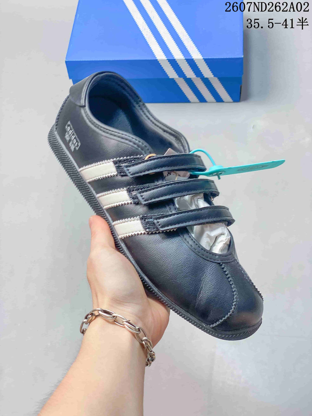Side view of a black adidas Originals ANFU shoe with contrasting stripes and a flat sole.