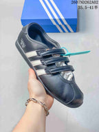 Side view of a black adidas Originals ANFU shoe with contrasting stripes and a flat sole.