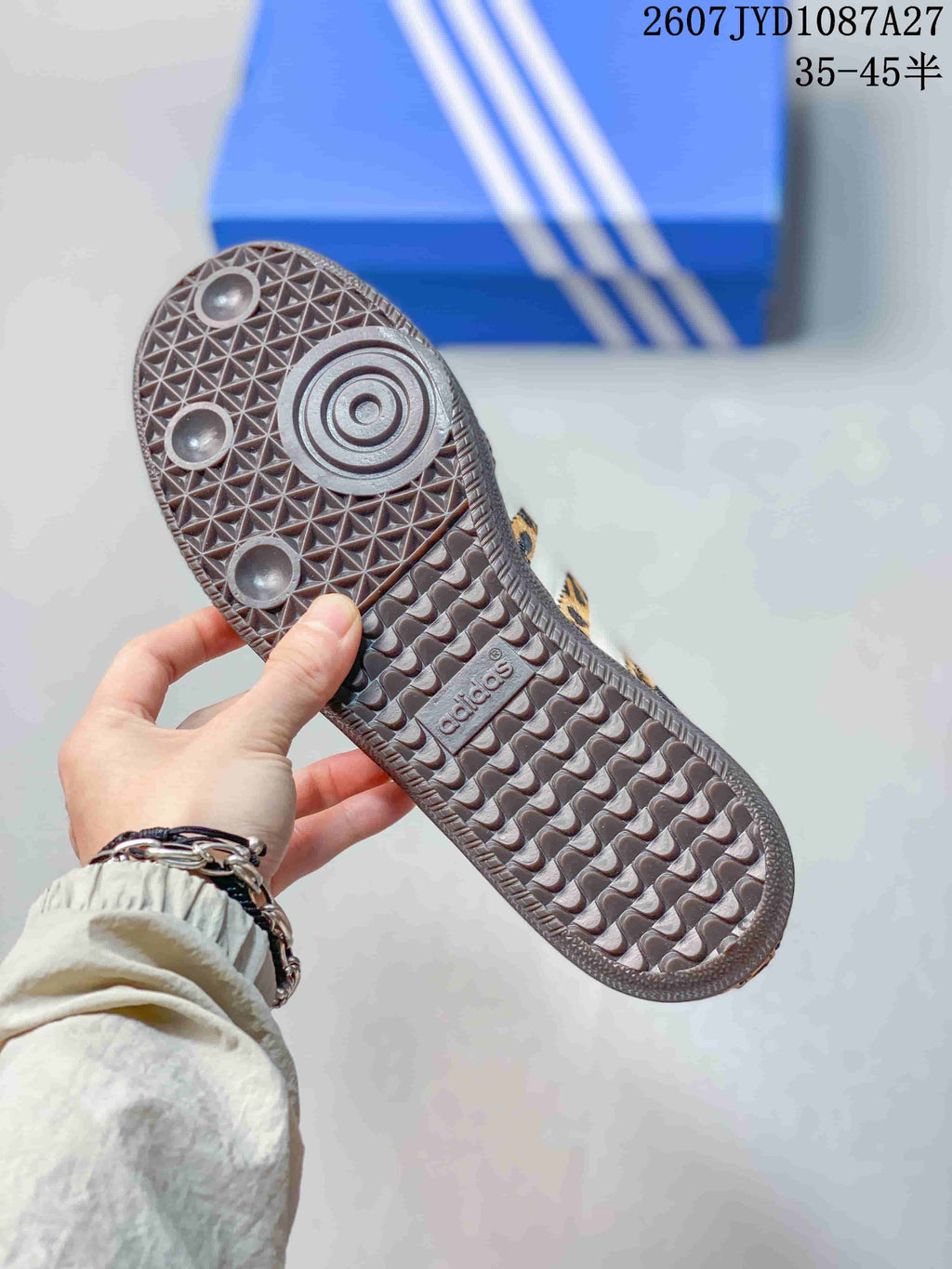 Close view of the dark patterned rubber outsole on a leopard-print sneaker, with adidas branding visible.