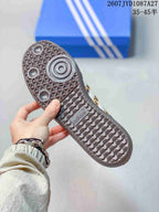 Close view of the dark patterned rubber outsole on a leopard-print sneaker, with adidas branding visible.