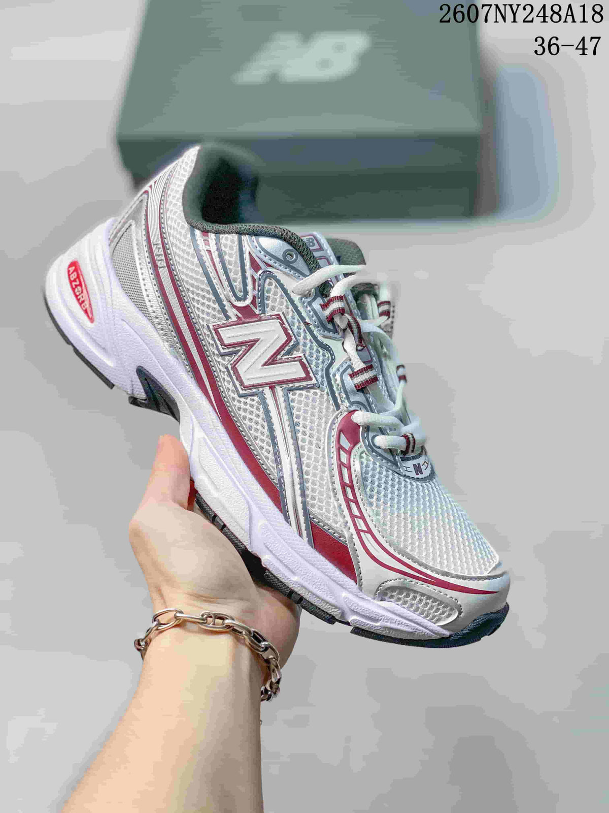 White and silver New Balance 740 sneaker with red accents and a dark outsole.