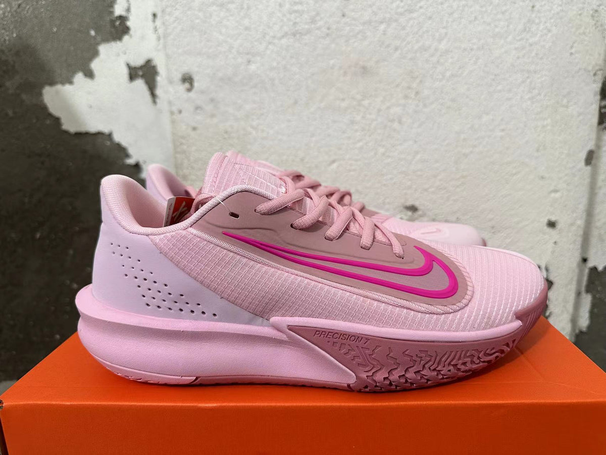 Side view showing the pink Nike Precision 7 shoe and patterned outsole