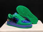 Angled view showing the green outsole with geometric tread, purple midsole and color-blocked upper.