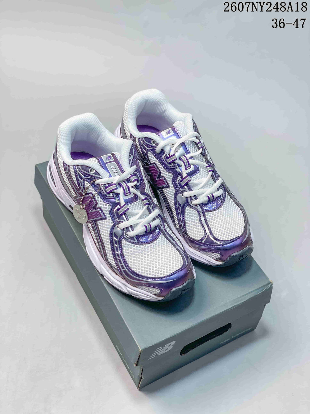 Pair of white and purple New Balance 740 sneakers displayed on a shoebox; image text shows 2607NY248A18 and 36–47.