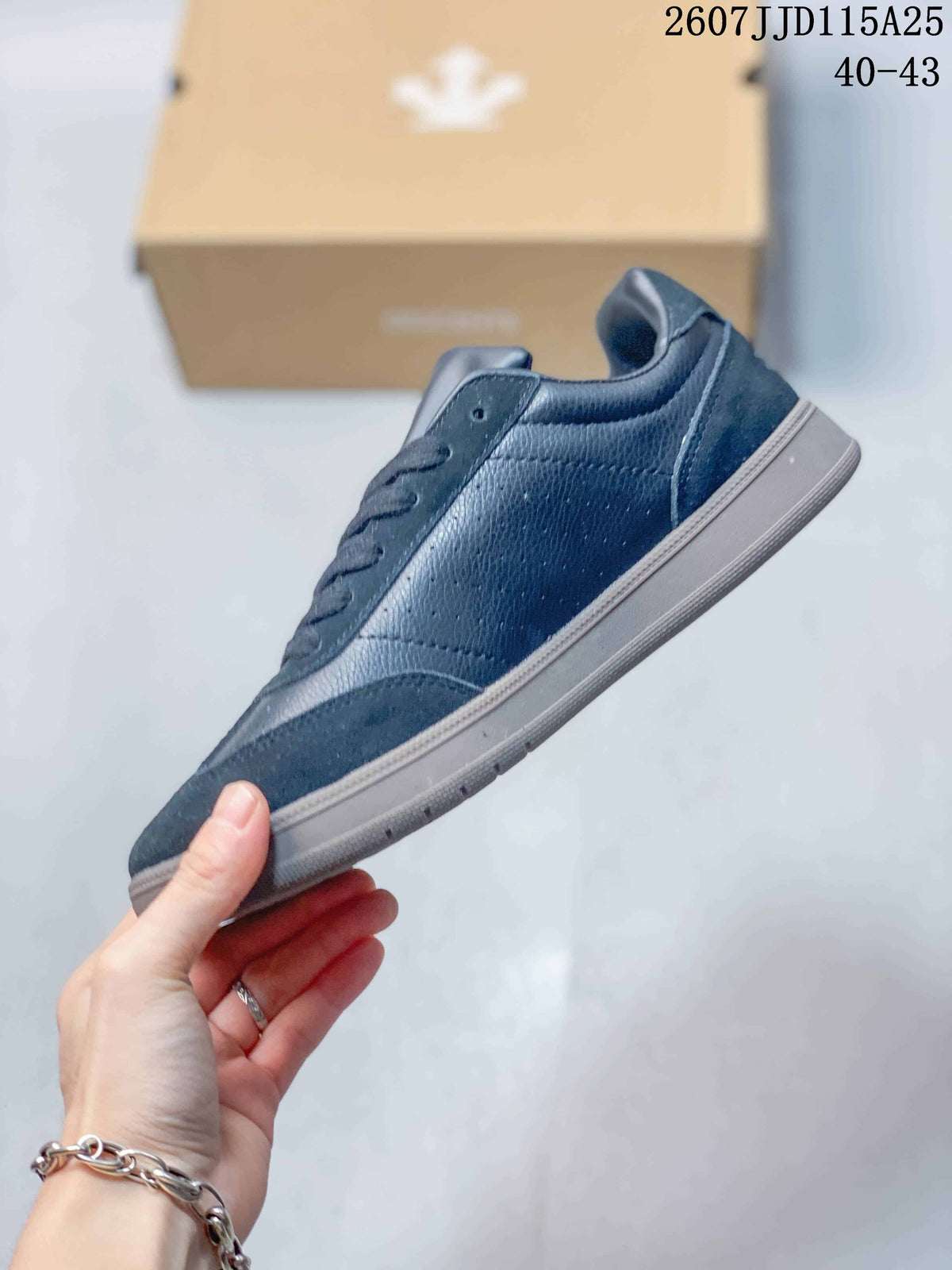 Side profile of the dark low-top sneaker showing the lace-up construction, textured upper panels and gray outsole.