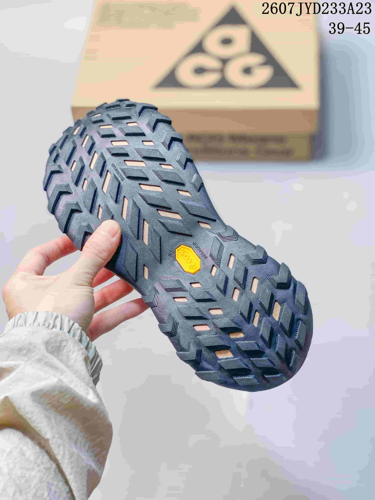 Close-up of the rugged black outsole with a patterned tread and a visible yellow insert.