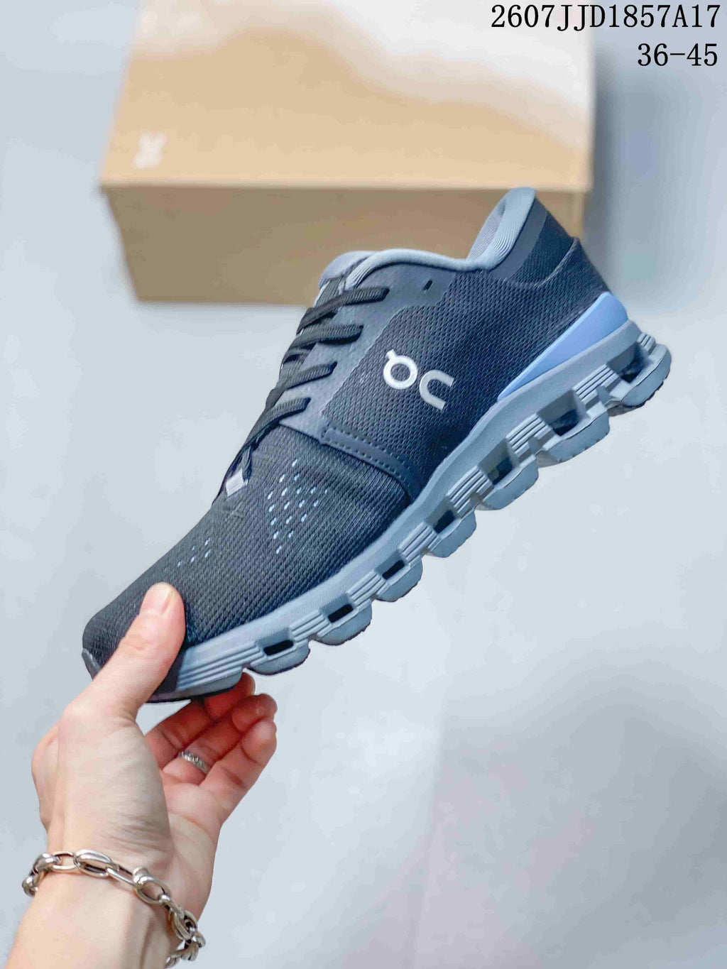 Side profile of the dark gray On sneaker showing the knit-style upper, lace-up construction, and segmented outsole.