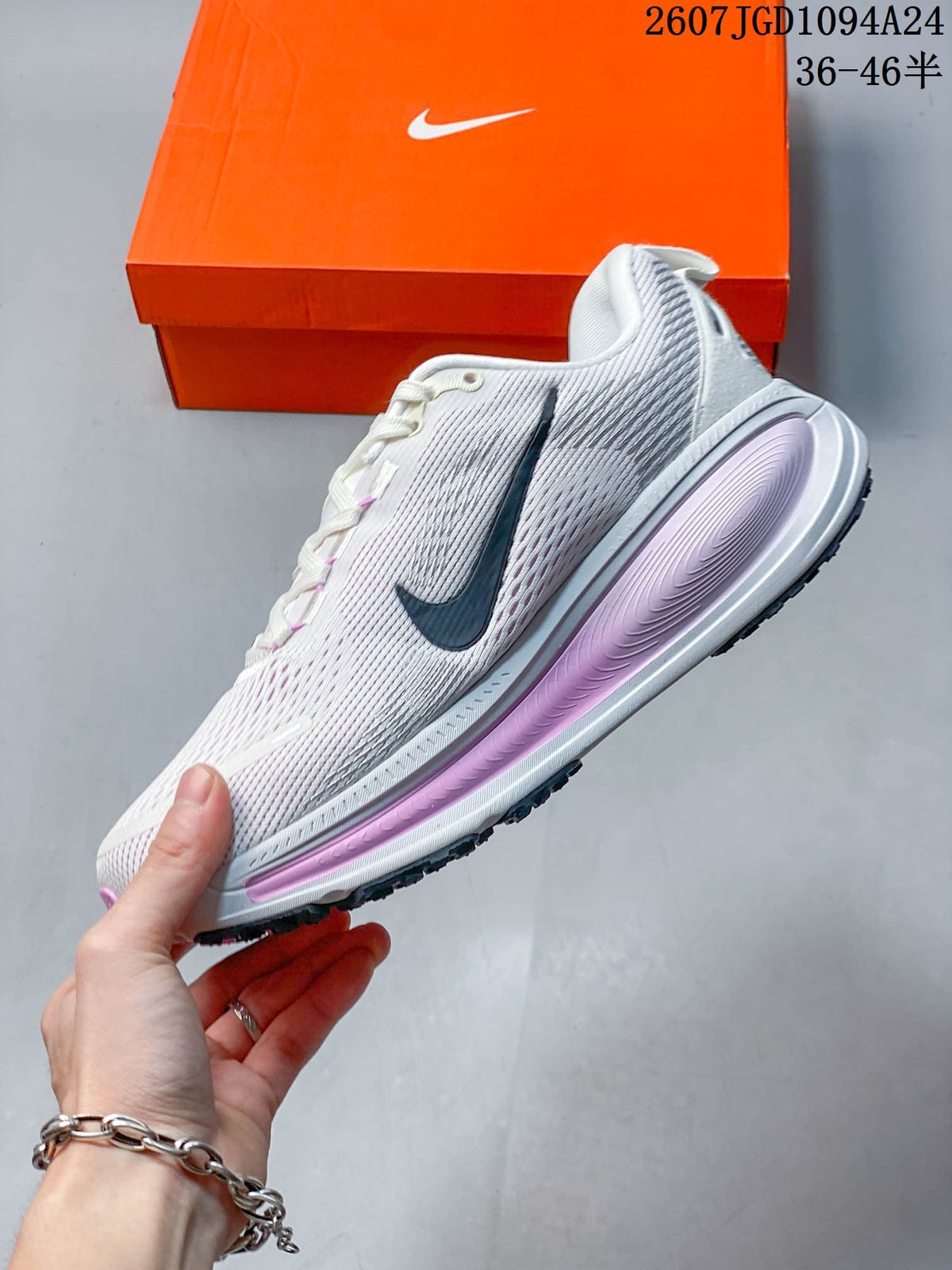 Side profile of the white and pink sneaker showing the dark Swoosh, textured upper, and layered midsole.