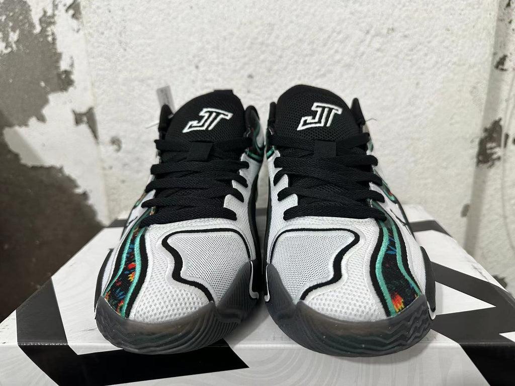 Front view of black, white, and green Jordan basketball shoes with floral-patterned side accents.