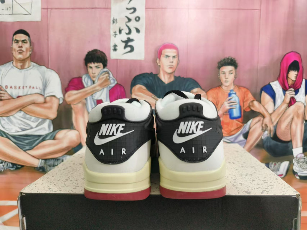 Rear view of black and white Nike Air sneakers with cream-toned midsoles and red outsole accents.