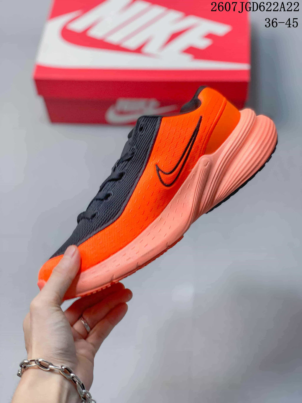 Side profile showing the orange upper, black Swoosh, laces, and textured sole.