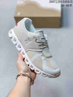 Angled side view of a white and light gray On CloudTilt sneaker showing the mesh upper, side branding, laces, and segmented outsole.