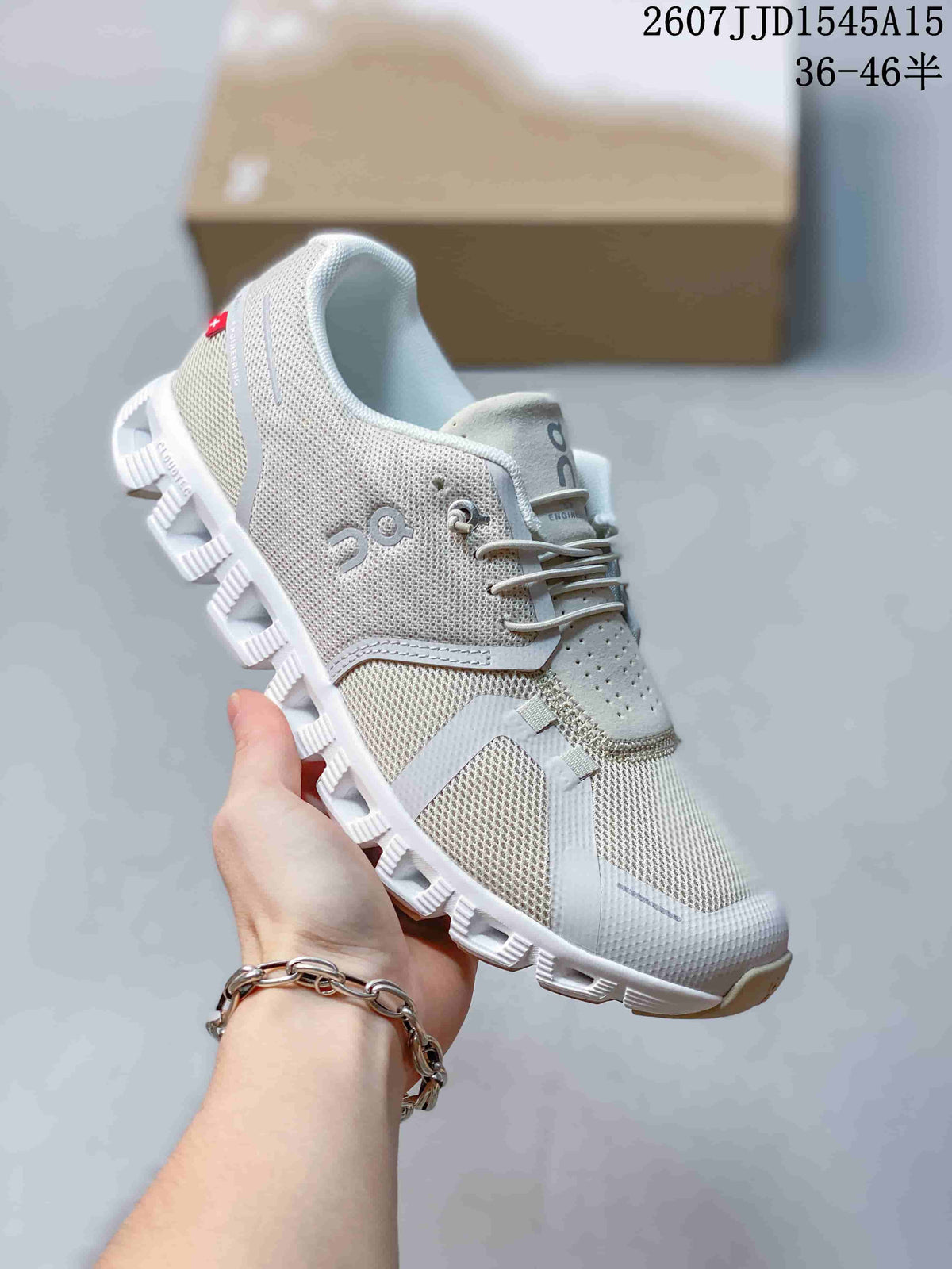 Angled side view of a white and light gray On CloudTilt sneaker showing the mesh upper, side branding, laces, and segmented outsole.
