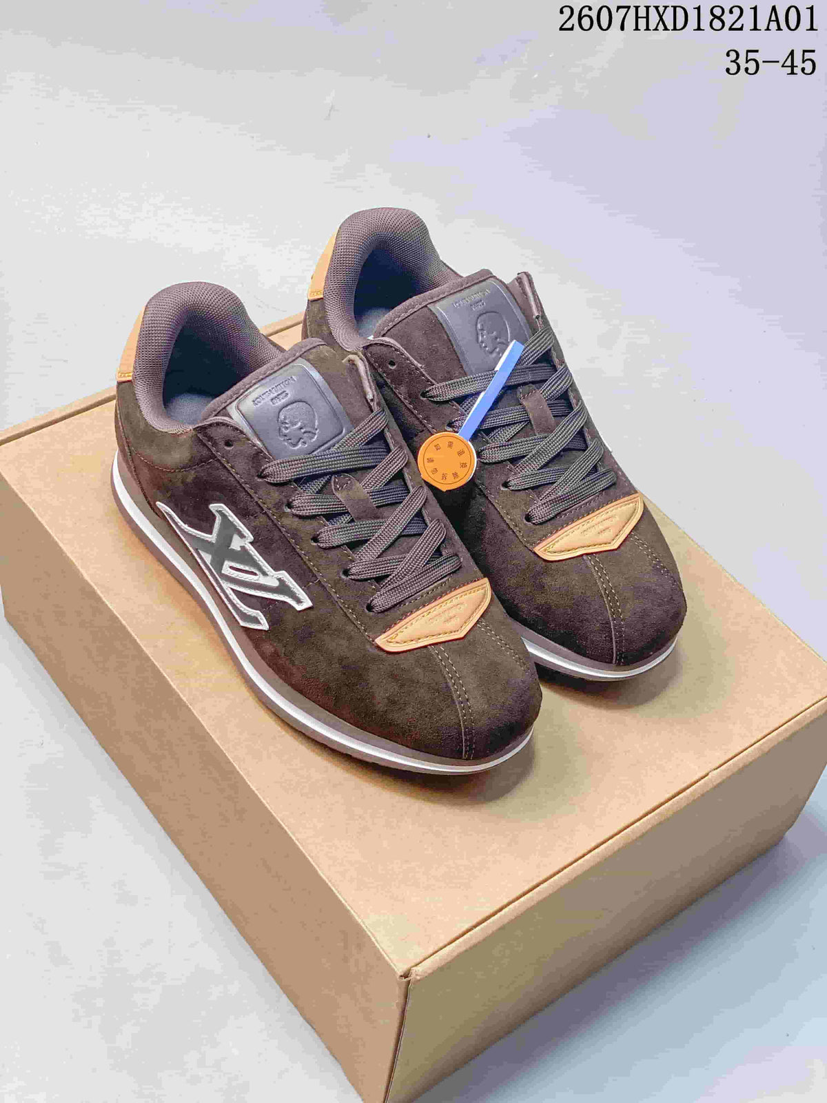 Pair of dark brown Buttersoft low-top sneakers with tonal laces, contrasting side emblems and light accents, displayed on a box.
