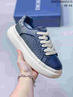 Close-up side view of a navy Dior sneaker showing the woven side panel, cream laces, padded collar, and thick light-colored outsole; overlay shows style code 2607GDD605A15 and size range 39–44.