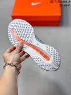 Close-up of the sneaker outsole showing a gray-and-white tread pattern with an orange central section.