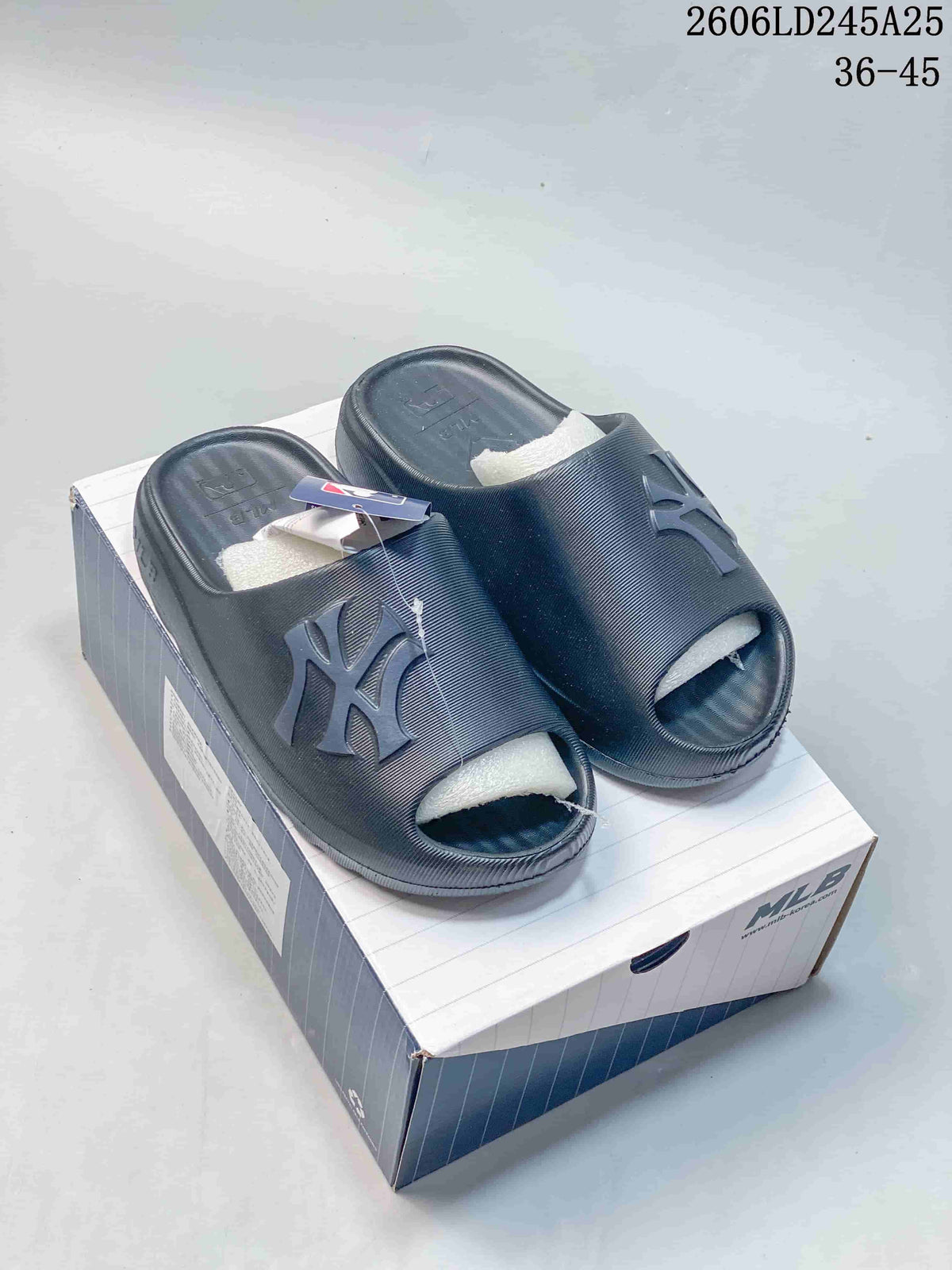 Pair of dark navy open-toe slide sandals with raised NY lettering.