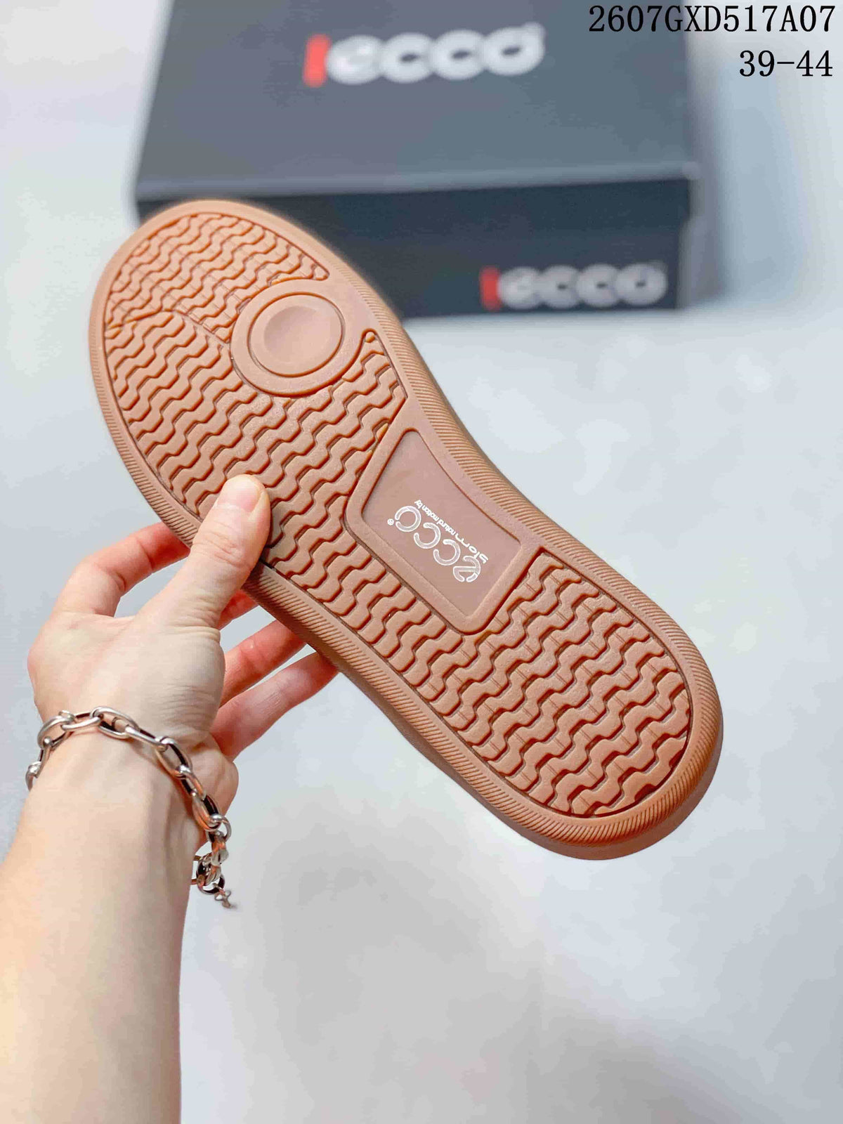 Bottom view of the sneaker showing the gum-colored rubber outsole with a repeating textured tread pattern; ECCO branding and size range 39-44 are visible in the background.