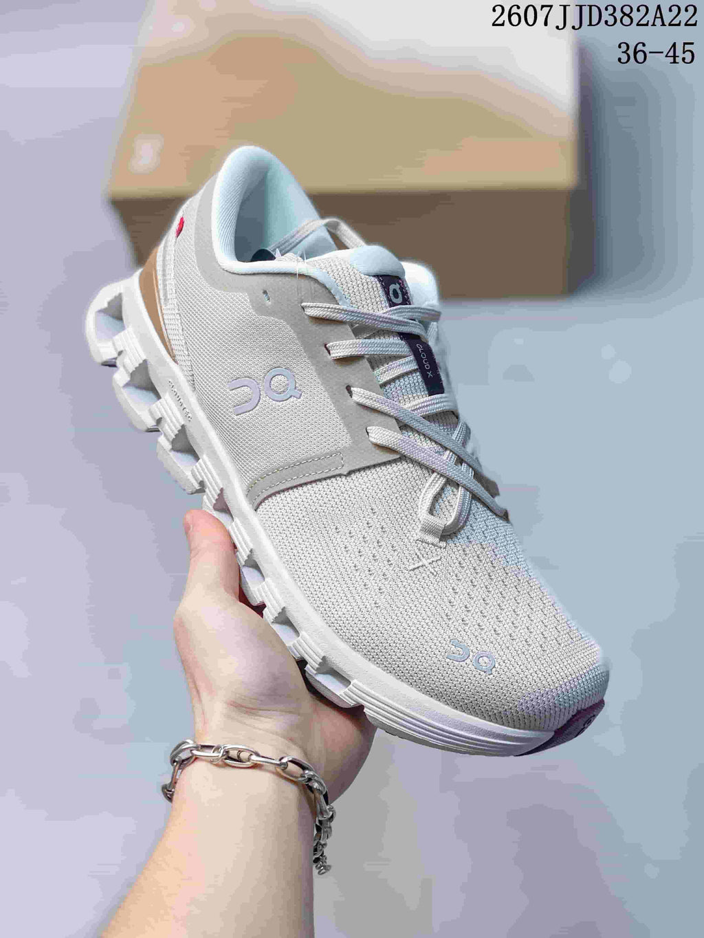 Three-quarter view of the light gray On Cloud X 4 sneaker showing the side logo, lace system, padded collar, and segmented sole.