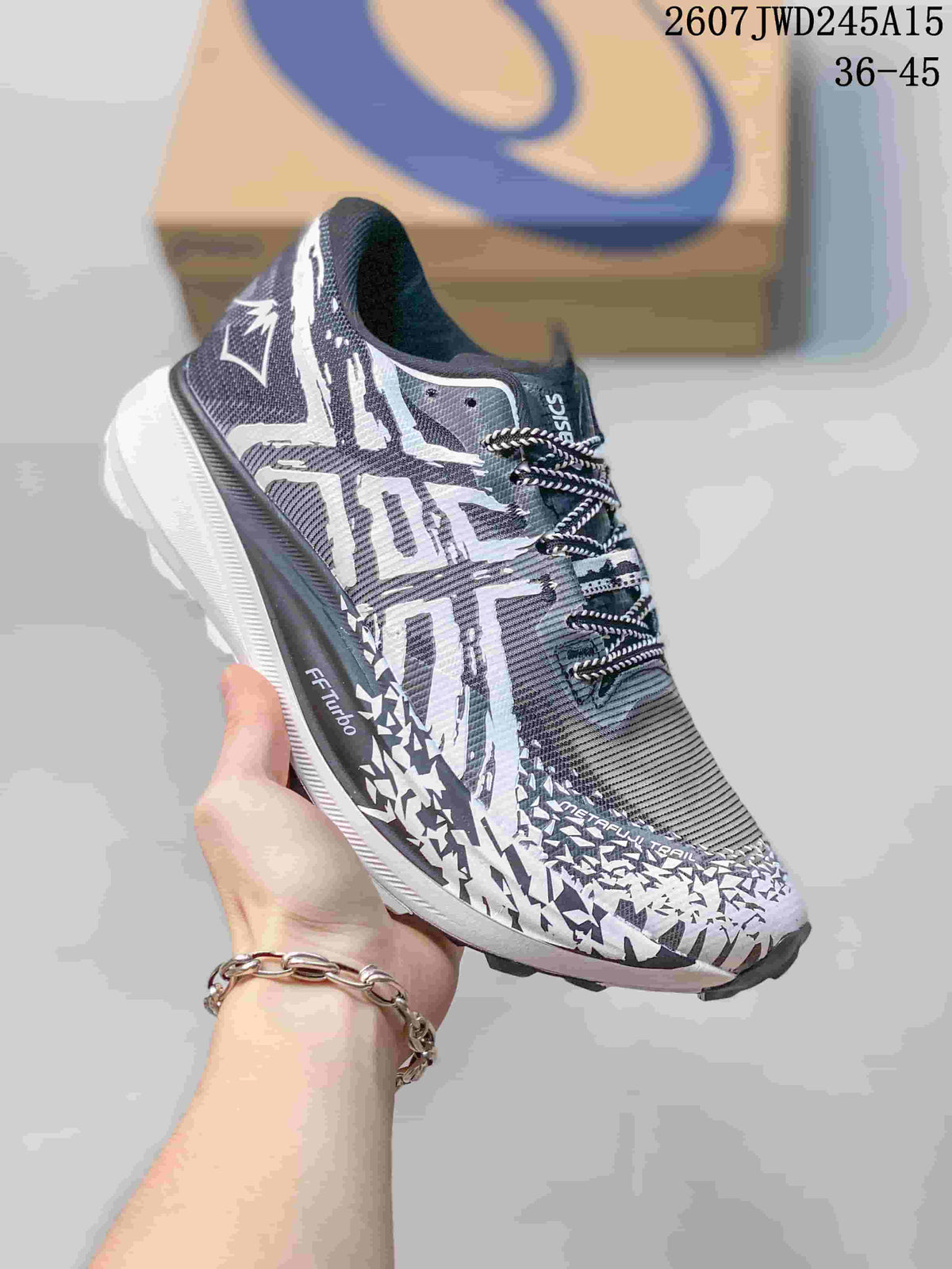Close-up of a black, white and gray ASICS sneaker with patterned upper, black laces and white midsole.