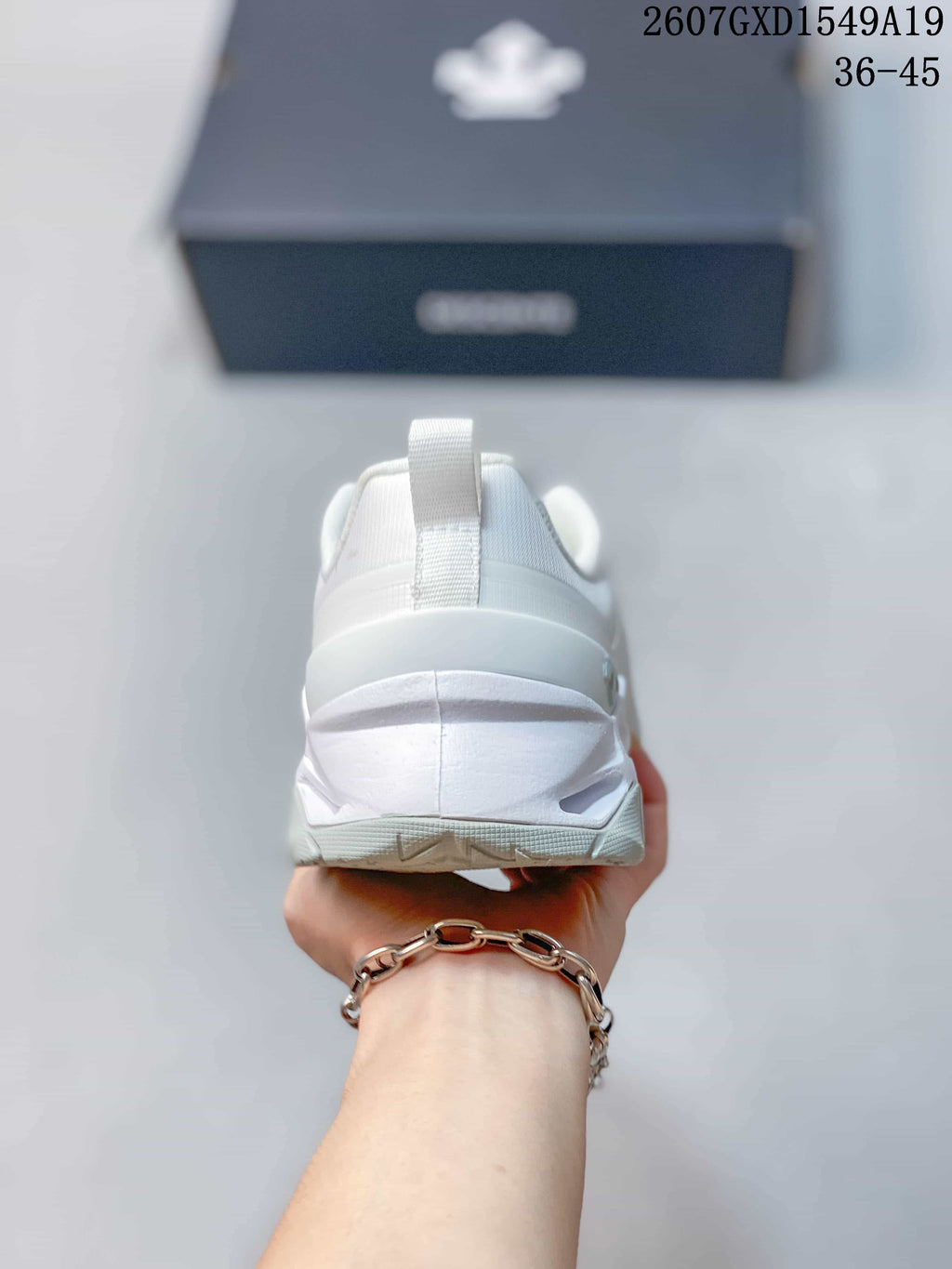 Rear view of the white sneaker showing the heel structure and pull tab.