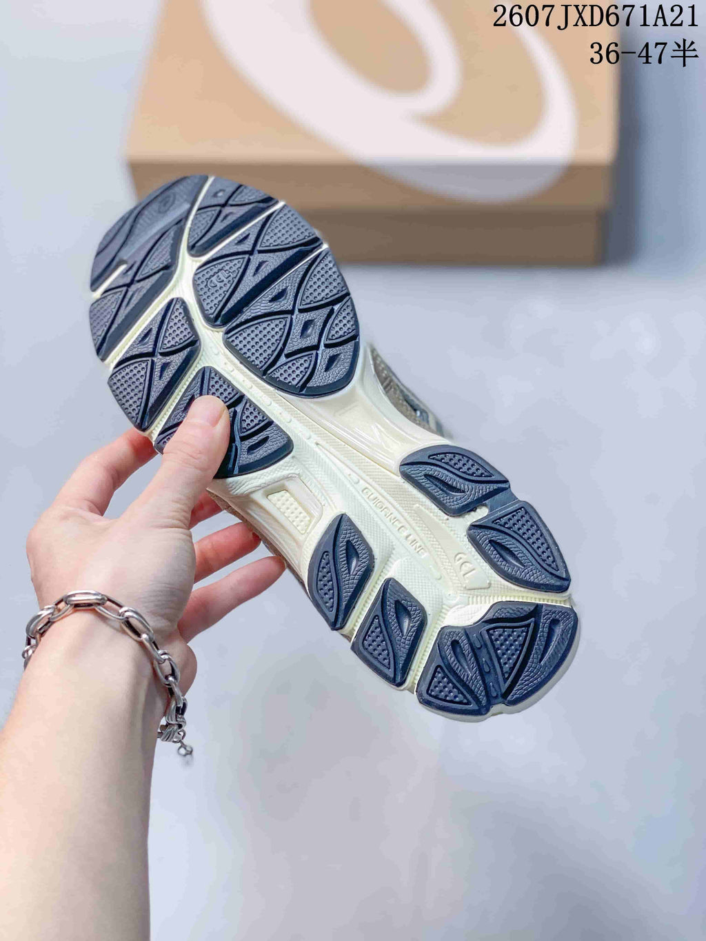 Underside view of an Asics sneaker showing the segmented rubber outsole and patterned tread.