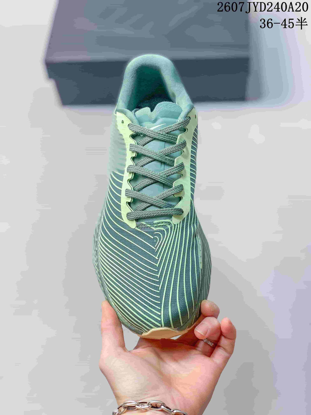 Top view of the sneaker showing the patterned toe box, gray laces, and contrasting pale green lace panel.