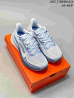 Pair of light blue and white Nike Air Zoom Pegasus 42 running shoes displayed on an orange shoebox.