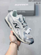 Three-quarter side view of the white and silver sneaker showing the layered upper, dark side logo, lace-up design, and black outsole.