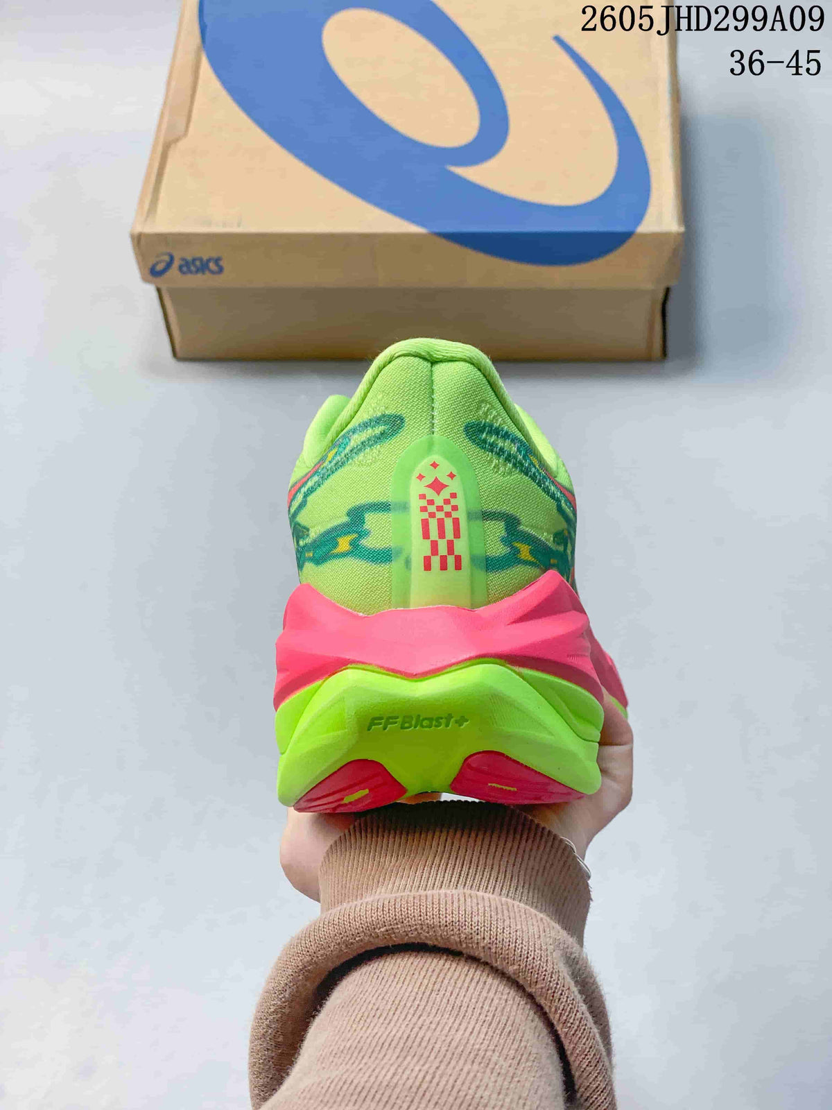Rear view of a lime green running shoe with pink heel details