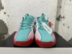 Front view showing turquoise tongues and laces, patterned side panels, and red toe accents.