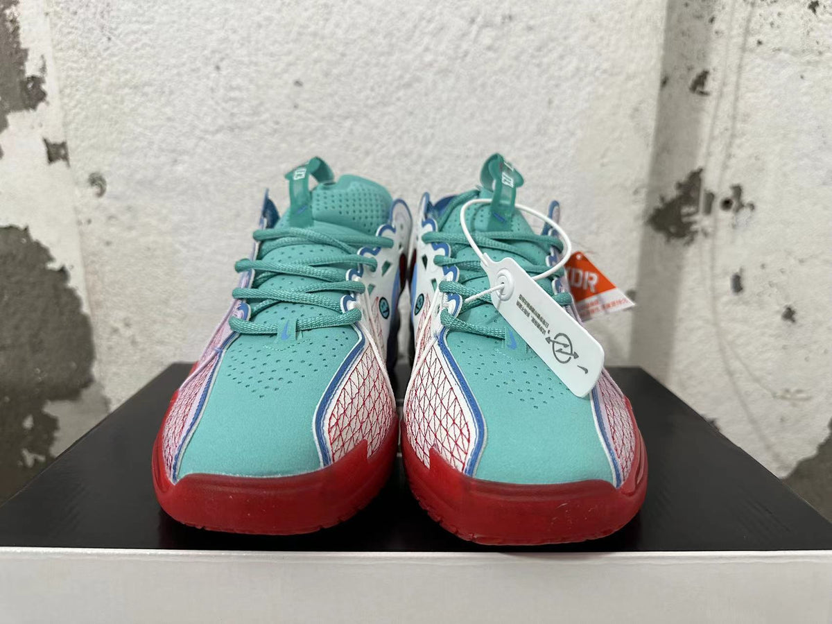 Front view showing turquoise tongues and laces, patterned side panels, and red toe accents.