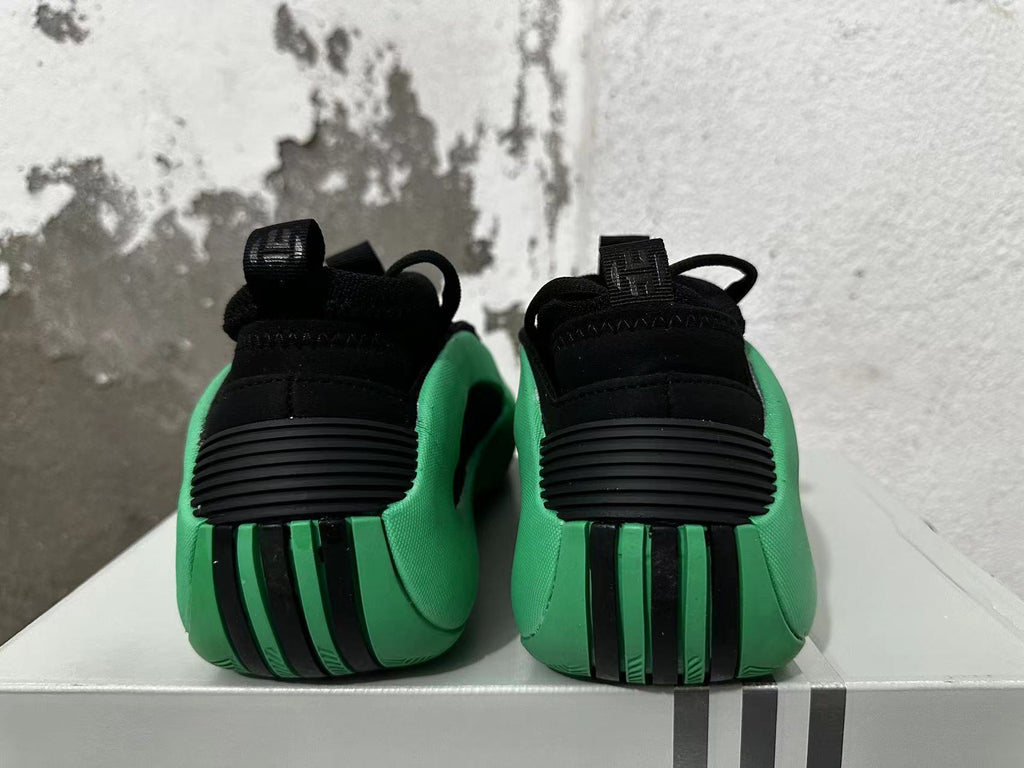 Rear view of black and green Adidas basketball shoes with ribbed heel details.