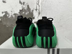 Rear view of black and green Adidas basketball shoes with ribbed heel details.