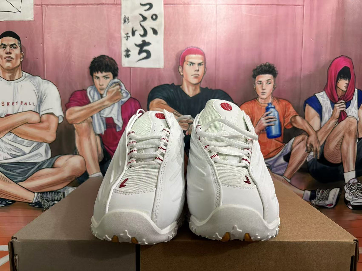 Front view of white lace-up sneakers with red detailing and mesh tongues