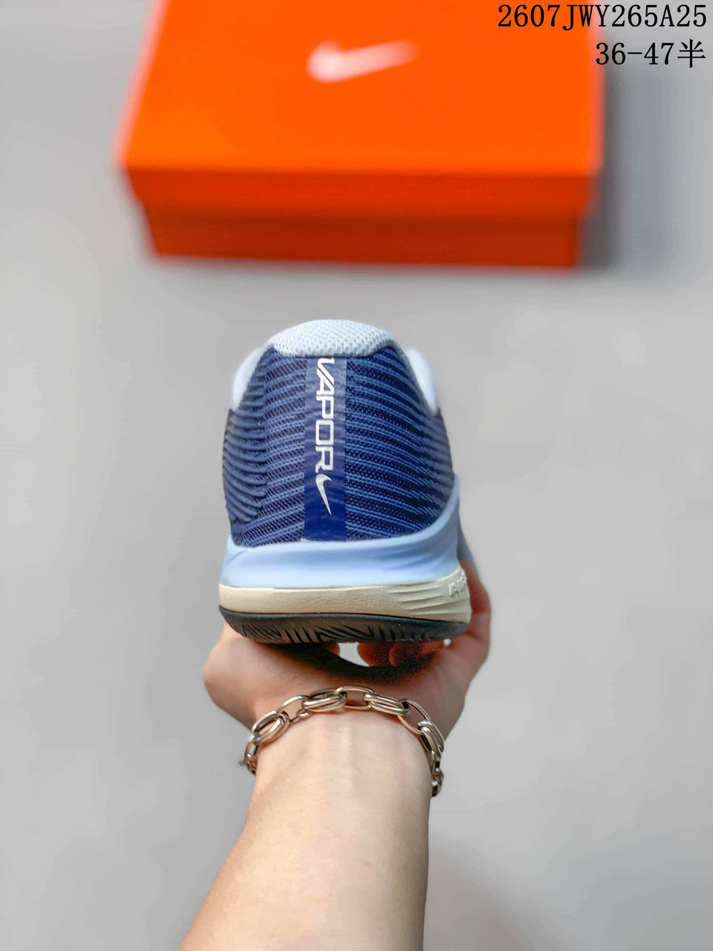 Rear view of a navy Nike Vapor 12 shoe showing the padded collar, heel branding, and layered midsole.