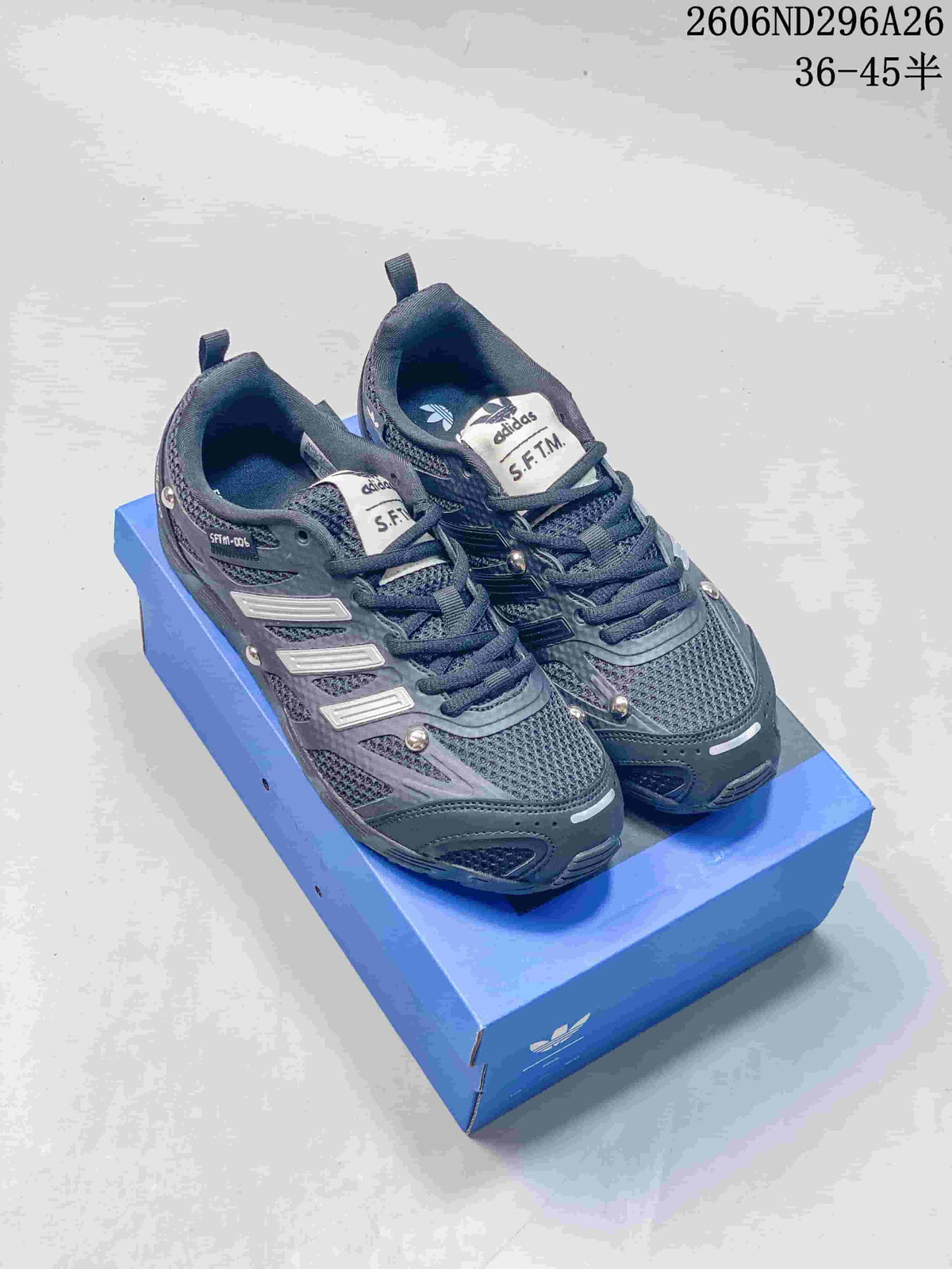 Pair of black and dark gray adidas Originals PR SFTM sneakers shown from above on a blue shoebox.