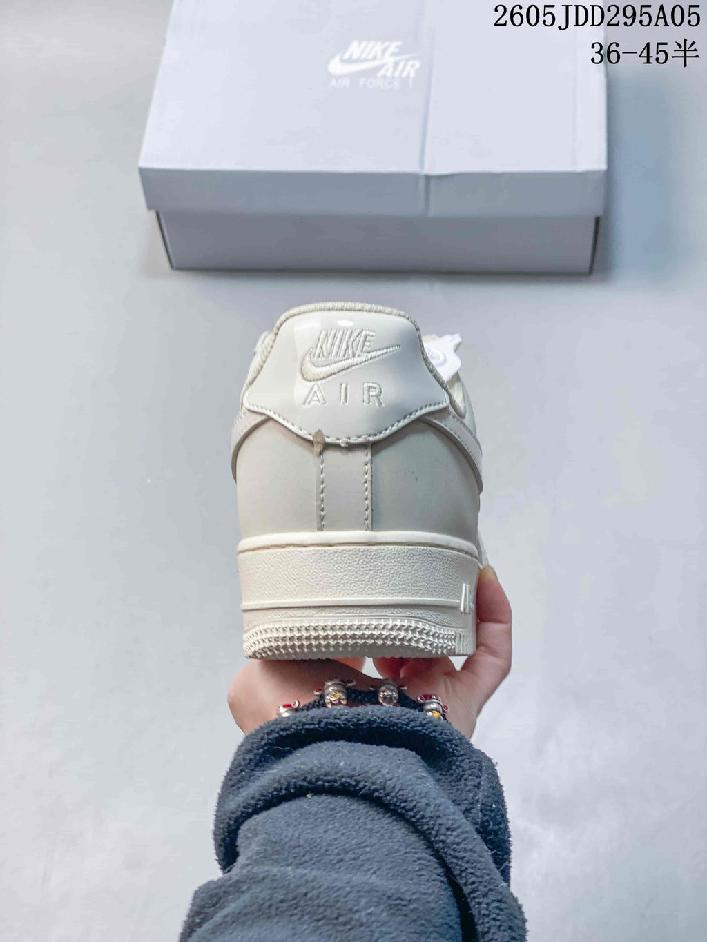 Rear view of a cream sneaker showing the Nike Air heel tab and layered heel construction.