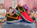 Angled view of multicolor basketball shoes with red, black, orange, purple, and neon green details.