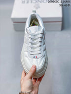 Top view of the white sneaker showing the laces, padded tongue, stitched panels and small colored detail near the lower lace area.