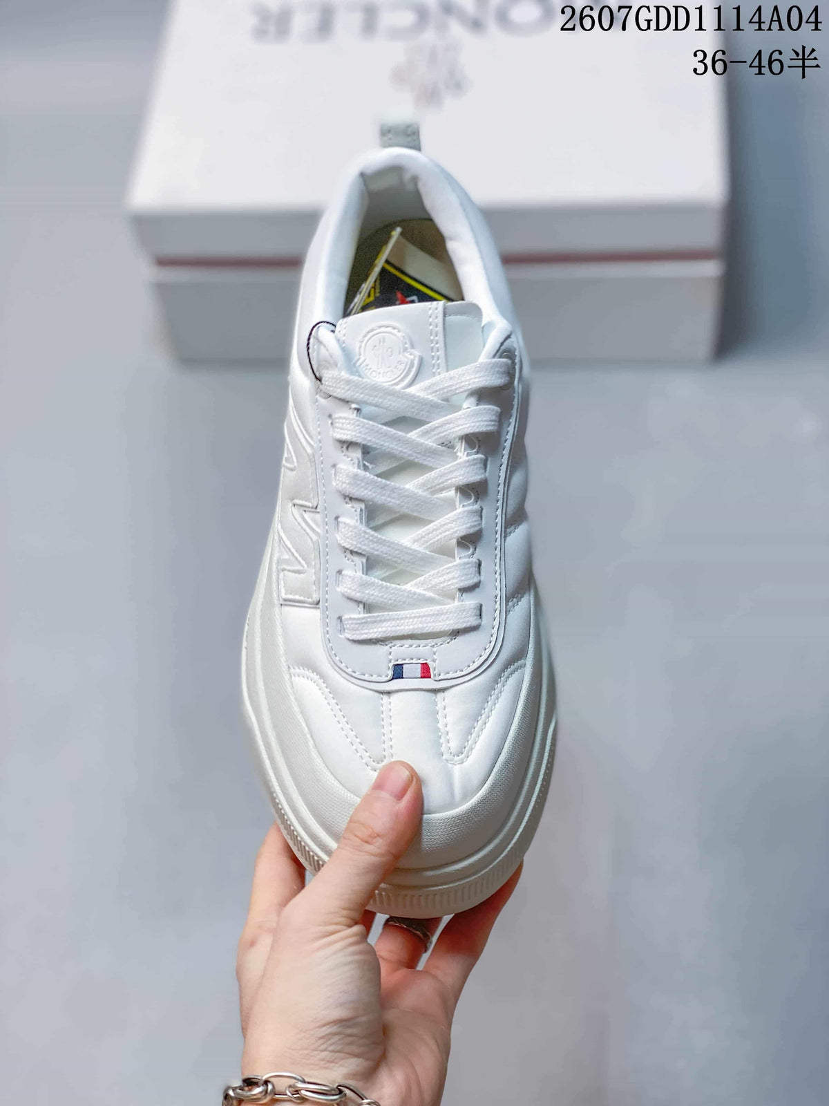Top view of the white sneaker showing the laces, padded tongue, stitched panels and small colored detail near the lower lace area.