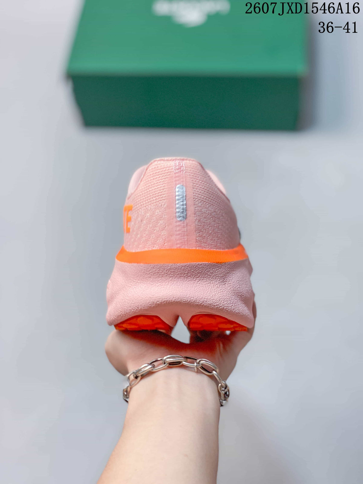 Rear view showing the pink heel, orange midsole accent, and orange outsole sections.
