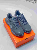 Pair of dark black Nike Vomero 18 sneakers displayed on an orange shoe box; visible text shows style code 2607JHY971A21 and size range 39-45.