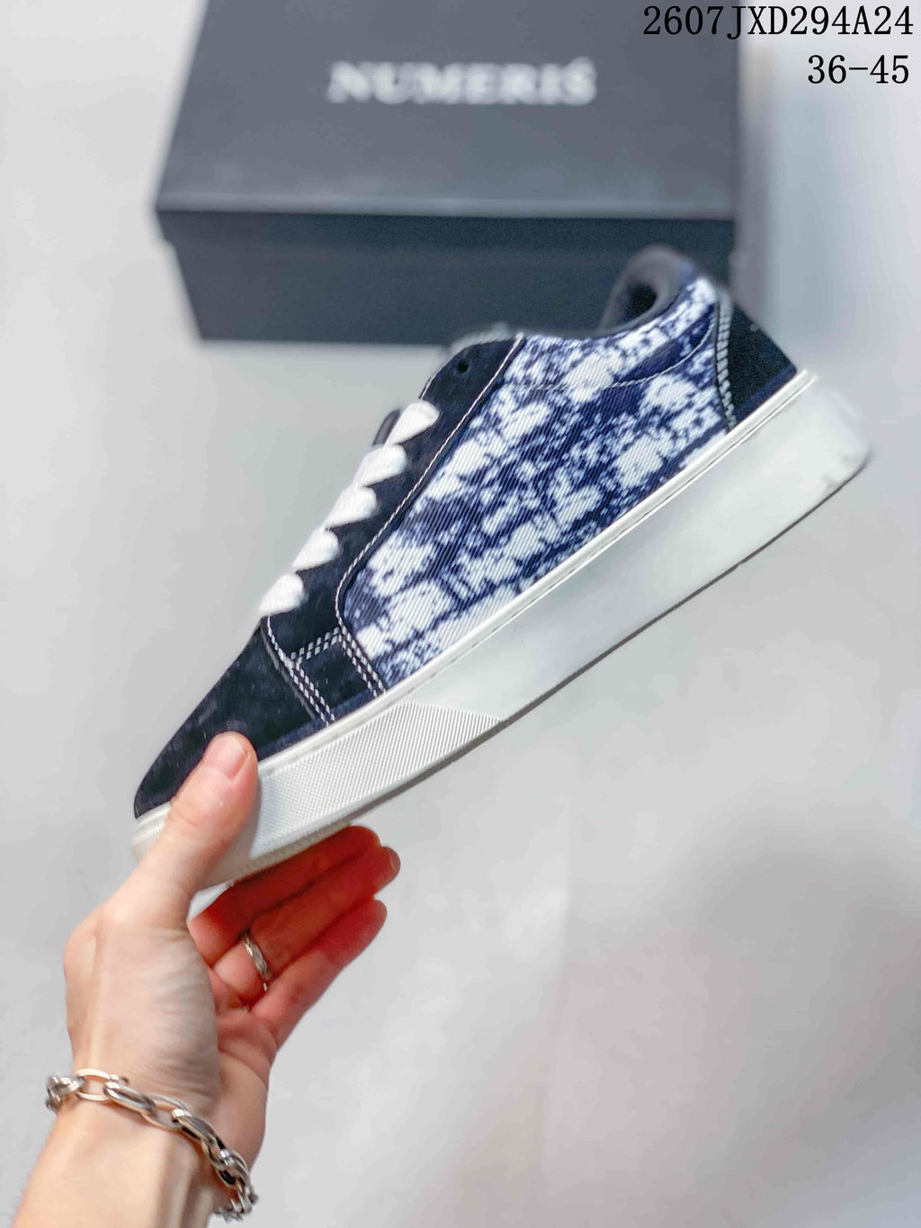 Side view showing the navy upper, patterned side panel, white stitching, and white outsole