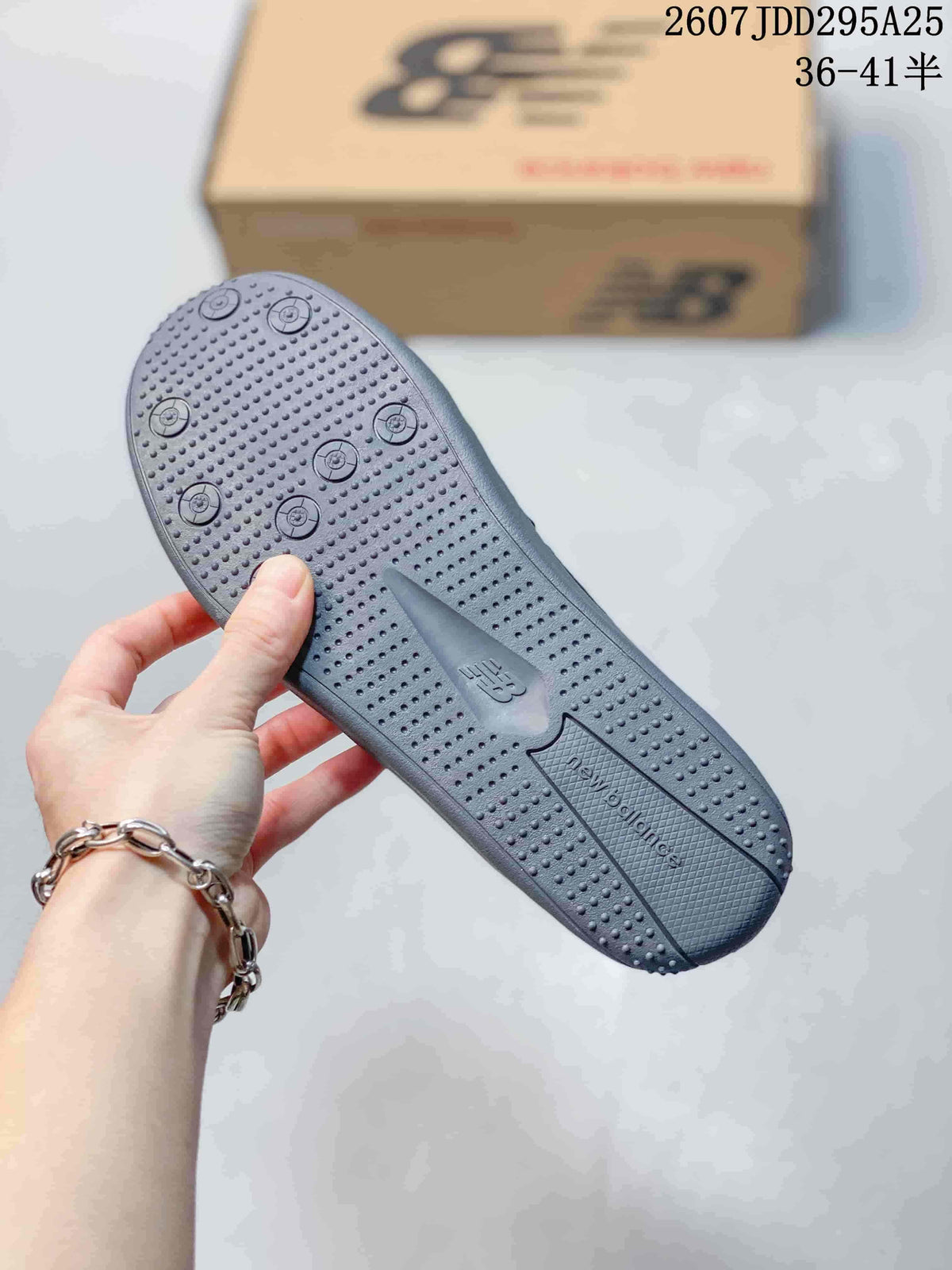 Close-up of the gray outsole showing raised circular tread details and textured sections.