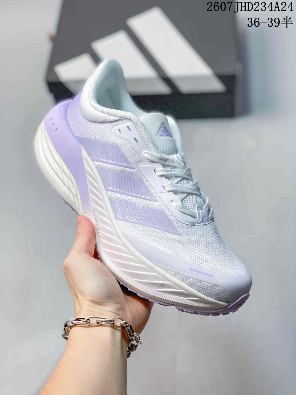 Angled side view showing the white and lavender upper, side branding, and cushioned-looking sole profile.