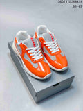 Pair of orange and gray Prada low-top sneakers displayed on a shoebox, with the product code and size range visible above.