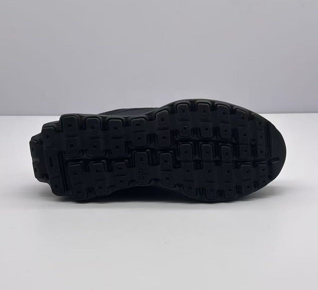 Underside view of the sneaker showing the black outsole with a segmented patterned tread.