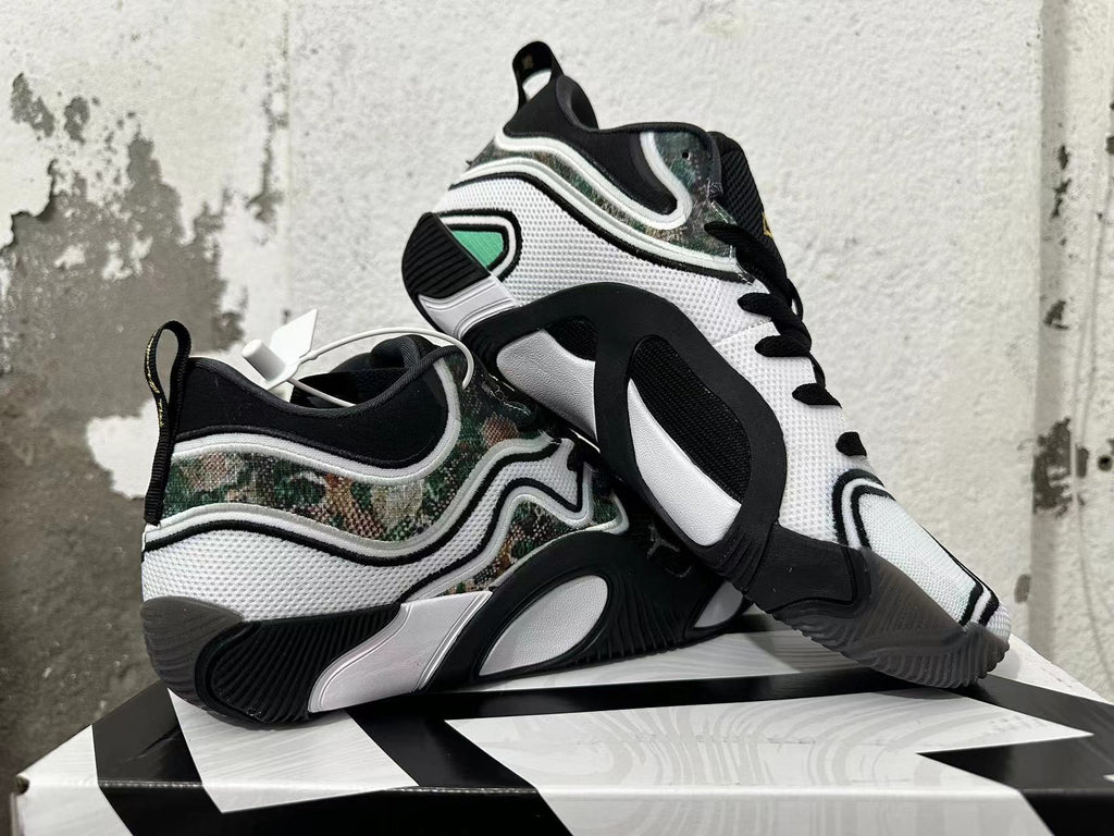 Pair of white and black sneakers displayed to show the side panels and outsole